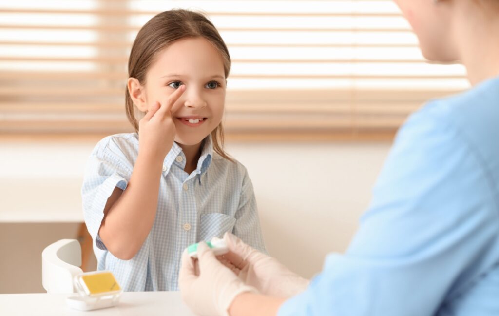 A child practices putting on their corrective contact lenses to help slow their myopia progression.