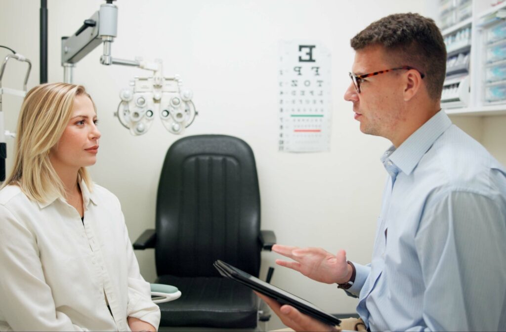 A person sits in an exam chair facing an optometrist having a conversation