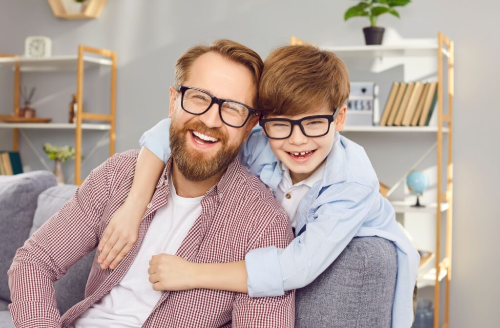 A father and child both wearing glasses while smiling together